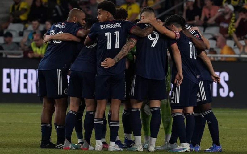 Futbolistas de New England Revolution se abrazan antes de enfrentar un partido por la MLS durante la temporada 2023.