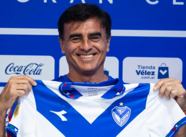 Gustavo Quinteros sostiene la camiseta de Vélez Sarsfield y sonríe ante las cámaras en su presentación oficial en el conjunto de Liniers de cara a la temporada 2024.