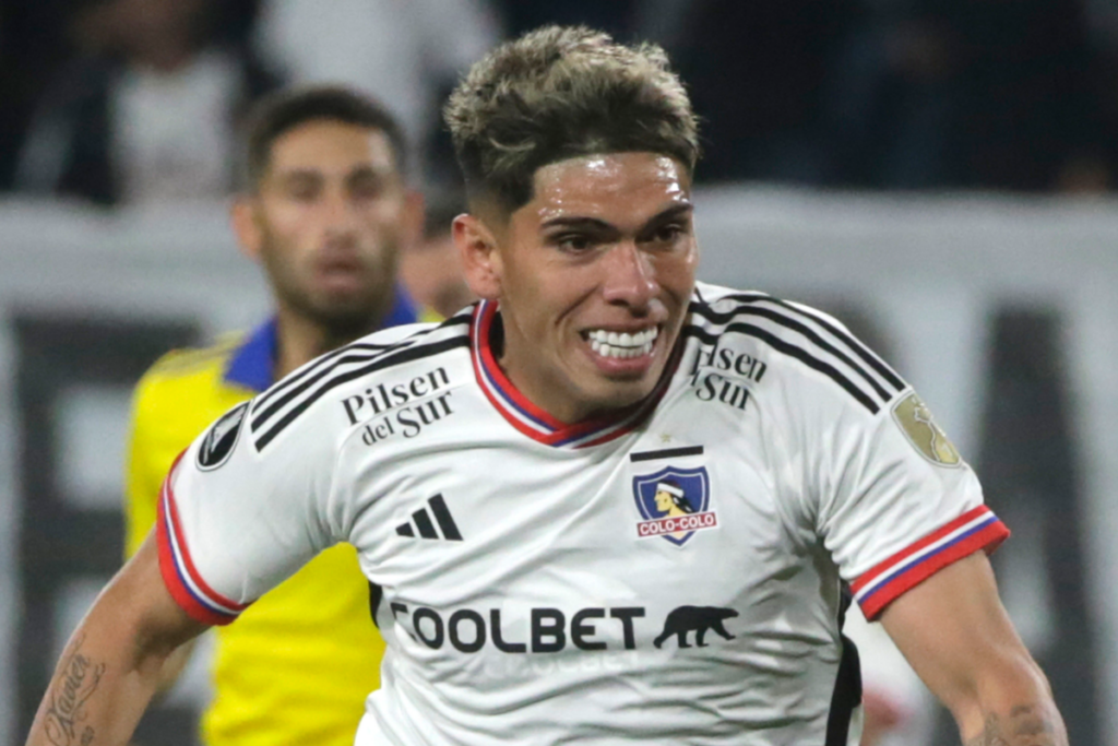 Carlos Palacios sonriendo y disputando un balón en pleno partido de Colo-Colo y Boca Juniors por la Copa Libertadores 2023.