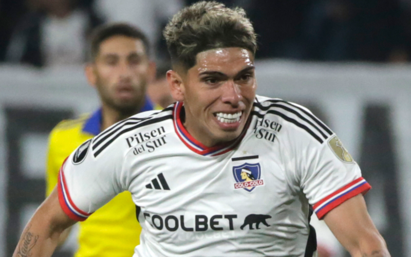 Carlos Palacios sonriendo y disputando un balón en pleno partido de Colo-Colo y Boca Juniors por la Copa Libertadores 2023.