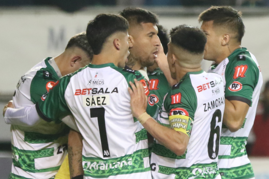 Futbolistas de Deportes Temuco se abrazan y celebran un gol durante la temporada 2023.
