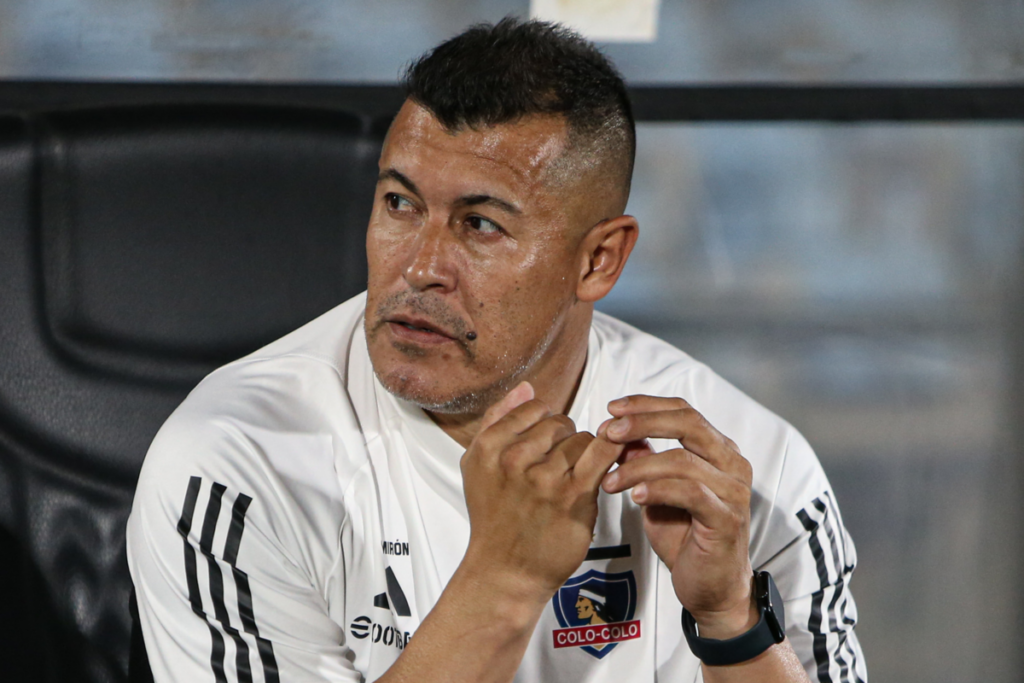 Jorge Almirón con cara pensativa se toma las manos en pleno partido con Colo-Colo durante la temporada 2024.