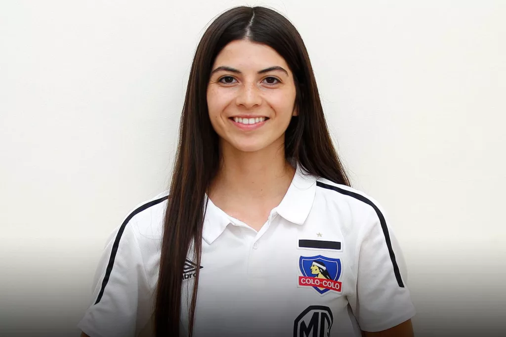 Melissa Bustos posando sonriendo con la camiseta de Colo-Colo.