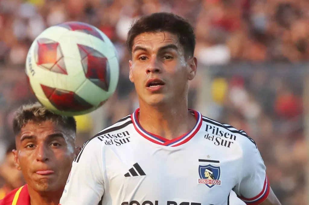 Primer plano al rostro de Erick Wiemberg con camiseta de Colo-Colo y un balón junto a él.