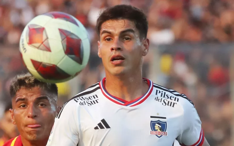 Primer plano al rostro de Erick Wiemberg con camiseta de Colo-Colo y un balón junto a él.