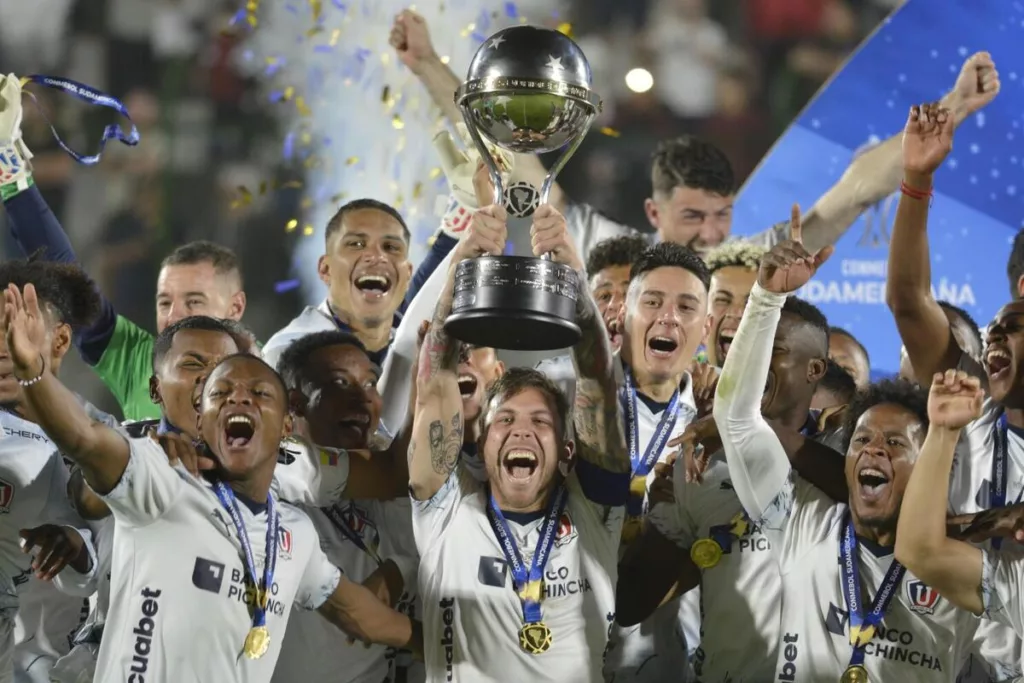 Futbolistas de Liga Universitaria de Quito celebran y levantan el trofeo de campeón de la Copa Sudamericana 2023.