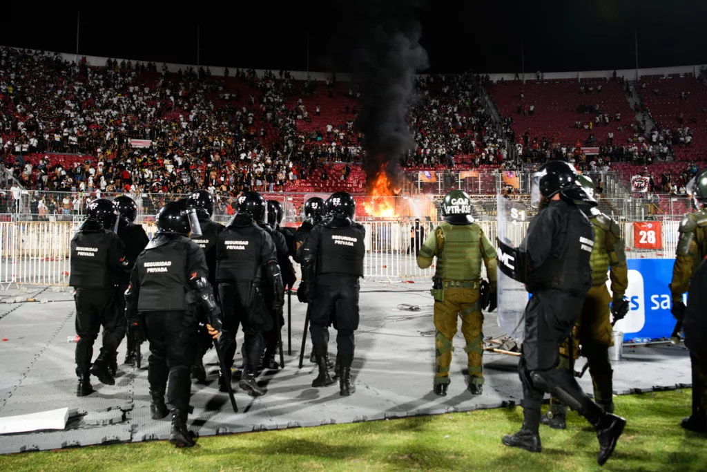 Efectivos de seguridad y Carabineros de Chile se dirigen al sector norte del Estadio Nacional tras altercaos de los hinchas de Colo-Colo, quienes incendian butacas en el recinto deportivo de Ñuñoa.