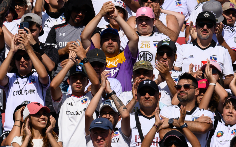 Hinchas de Colo-Colo aplauden y saludan a las cámaras durante la temporada 2024.