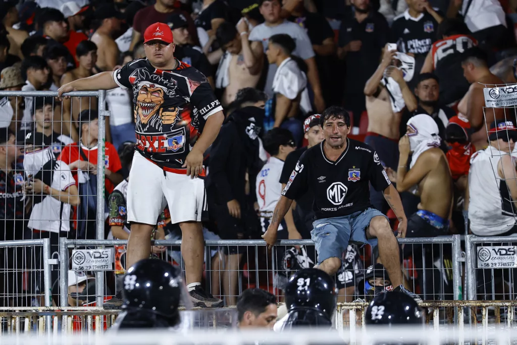 Hinchas de Colo-Colo sobre una de las rejas del Estadio Nacional.