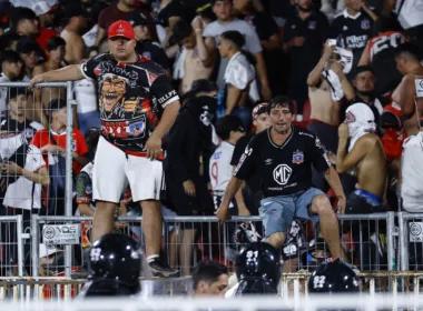 Hinchas de Colo-Colo sobre una de las rejas del Estadio Nacional.