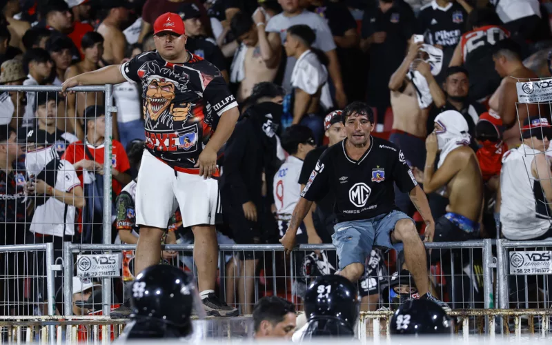 Hinchas de Colo-Colo sobre una de las rejas del Estadio Nacional.