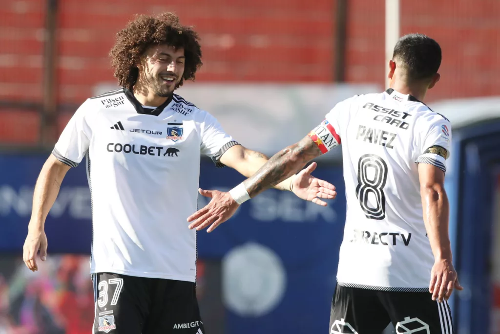 Maximiliano Falcón y Esteban Pavez saludándose en la cancha del Estadio Santa Laura.