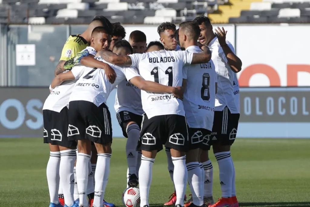 Jugadores de Colo-Colo abrazados en la cancha