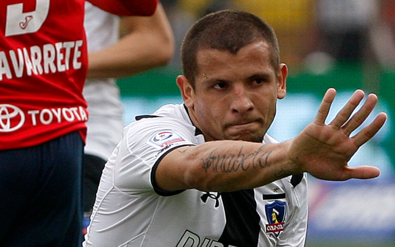 Emiliano Vecchio levanta su mano en señal de disculpas en pleno partido defendiendo la camiseta de Colo-Colo ante Unión Española.