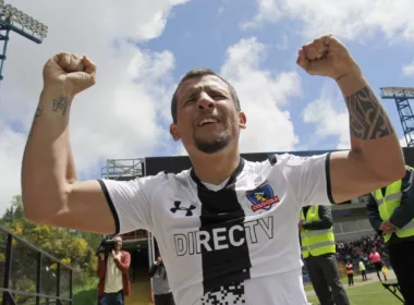 Emiliano Vecchio celebrando un gol con los brazos en alto con la camiseta de Colo-Colo.