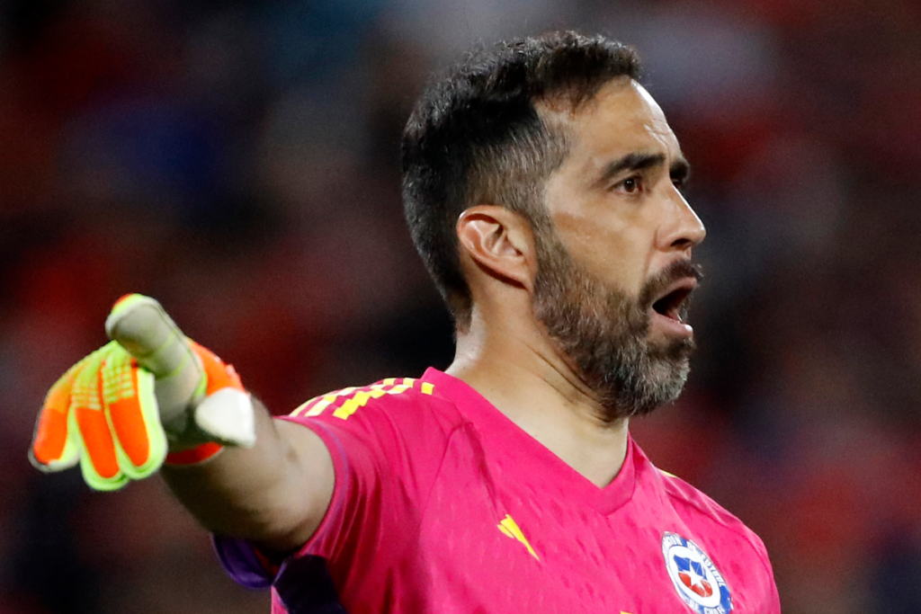 Claudio Bravo apuntando con su brazo derecho en pleno partido con la camiseta de la Selección Chilena de fútbol.