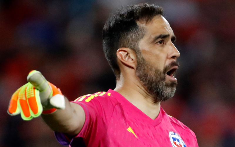 Claudio Bravo apuntando con su brazo derecho en pleno partido con la camiseta de la Selección Chilena de fútbol.