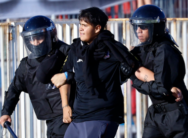 Hincha de Colo-Colo es detenido por dos uniformados tras serios incidentes en la Supercopa 2024.