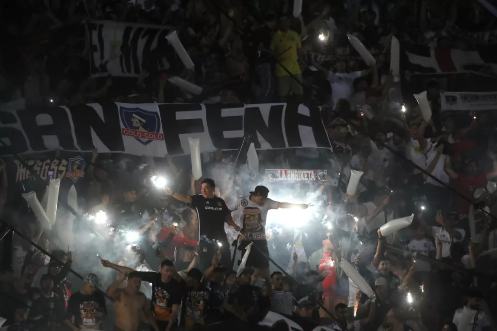 Hinchas de Colo-Colo encienden luces para darle la bienvenida al equipo en la antesala del duelo ante Godoy Cruz por la fase 2 de Copa Libertadores 2024 en el Estadio Malvinas Argentinas.