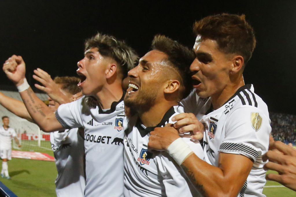 Los futbolistas de Colo-Colo Marcos Bolados, Erick Wiemberg y Carlos Palacios se abrazan y celebran eufóricos el 1-0 ante Godoy Cruz en el Estadio Malvinas Argentinas por la Copa Libertadores 2024.