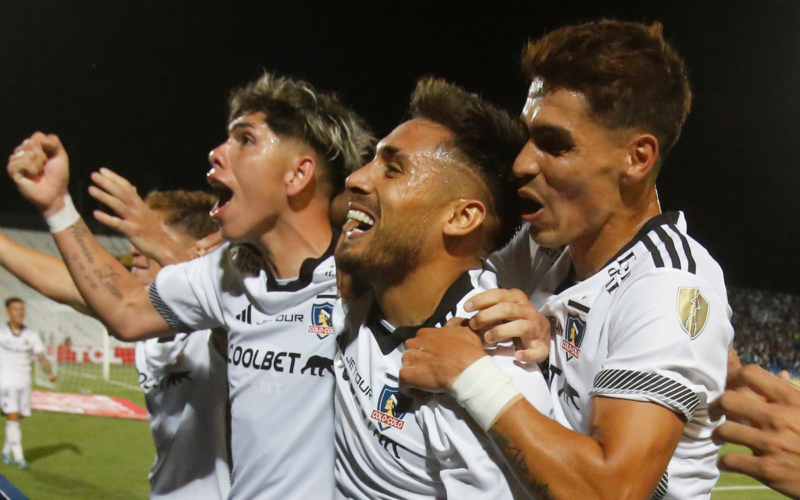 Los futbolistas de Colo-Colo Marcos Bolados, Erick Wiemberg y Carlos Palacios se abrazan y celebran eufóricos el 1-0 ante Godoy Cruz en el Estadio Malvinas Argentinas por la Copa Libertadores 2024.