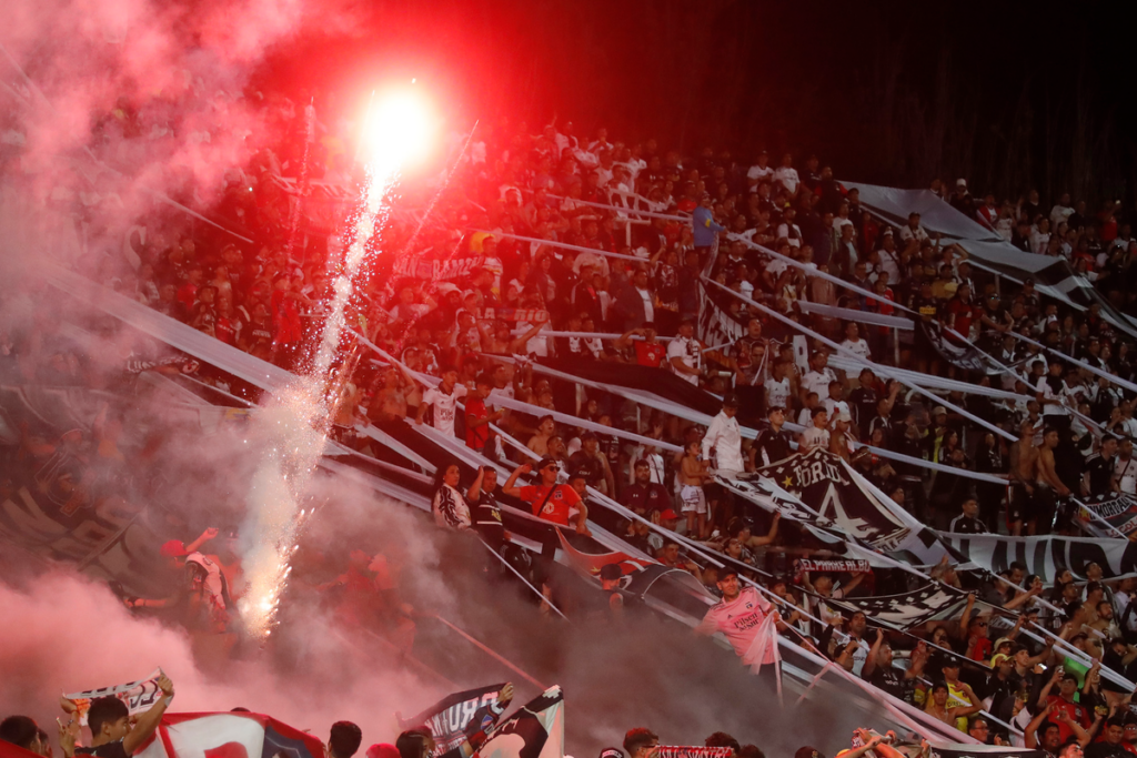 Hinchas de Colo-Colo lanzan bengalas y fuegos de artificio a la cancha del Estadio Malvinas Argentinas en el duelo ante Godoy Cruz por la fase 2 de Copa Libertadores 2024.