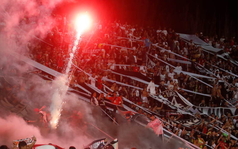 Hinchas de Colo-Colo lanzan bengalas y fuegos de artificio a la cancha del Estadio Malvinas Argentinas en el duelo ante Godoy Cruz por la fase 2 de Copa Libertadores 2024.