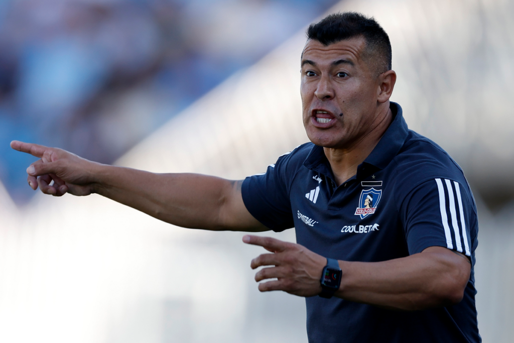 Jorge Almirón impartiendo una instrucción con sus brazos en pleno rol como director técnico de Colo-Colo durante la temporada 2024.