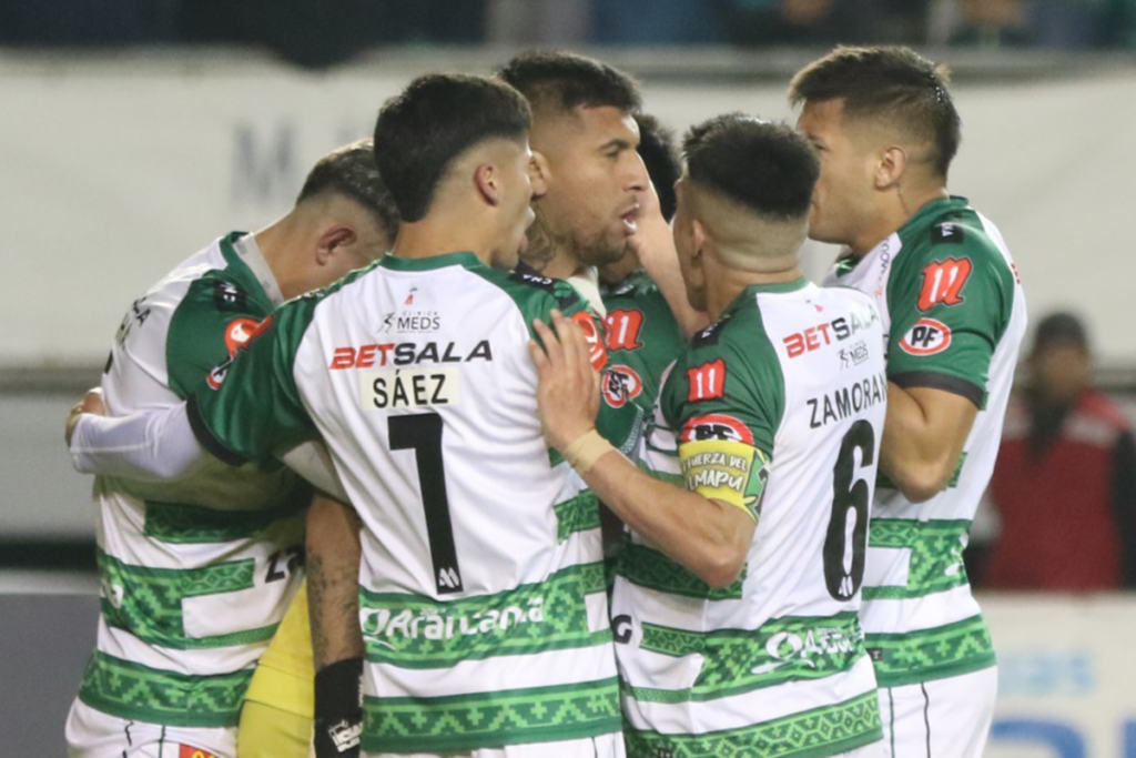 Futbolistas de Deportes Temuco se abrazan en plena celebración de un gol durante la temporada 2024.