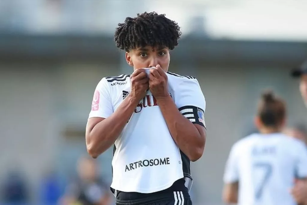 Primer plano a Yusmery Ascanio besando el escudo de Colo-Colo mientras celebra un gol.