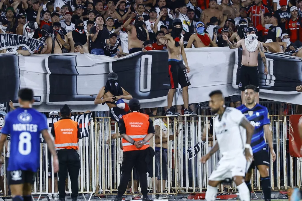 Garra Blanca sobre la reja del Estadio Nacional durante la Supercopa.