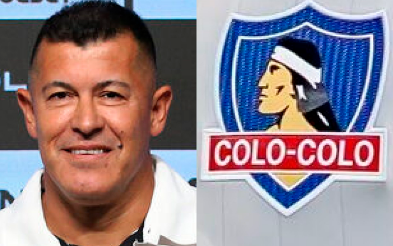 Jorge Almirón sonriendo ante las cámaras a mano izquierda de la imagen, mientras que en el sector derecho se puede observar el escudo de Colo-Colo.