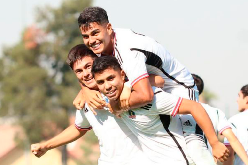 Futbolistas de Colo-Colo se abrazan y celebran un gol ante las cámaras en pleno partido por la Supercopa Proyección 2024 frente a Palestino.