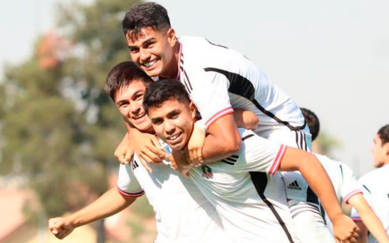 Futbolistas de Colo-Colo se abrazan y celebran un gol ante las cámaras en pleno partido por la Supercopa Proyección 2024 frente a Palestino.