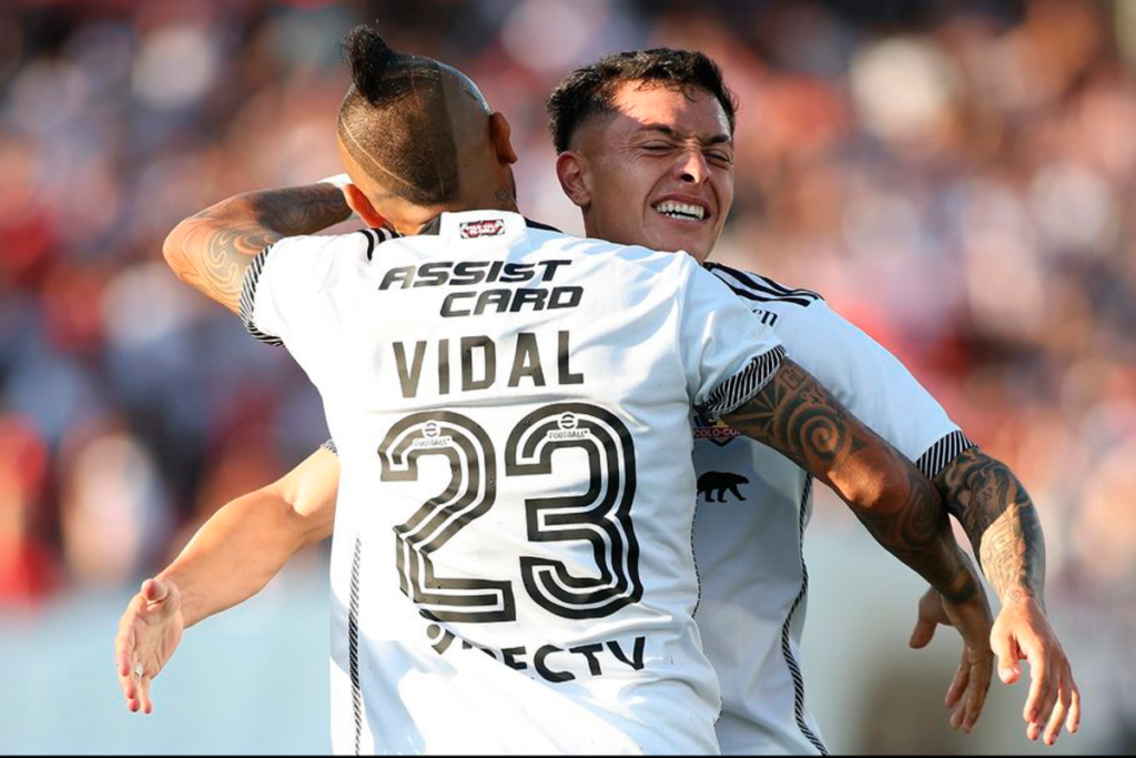 Cristián Zavala y Arturo Vidal se abrazan en plena celebración de un gol con la camiseta de Colo-Colo durante la temporada 2024.