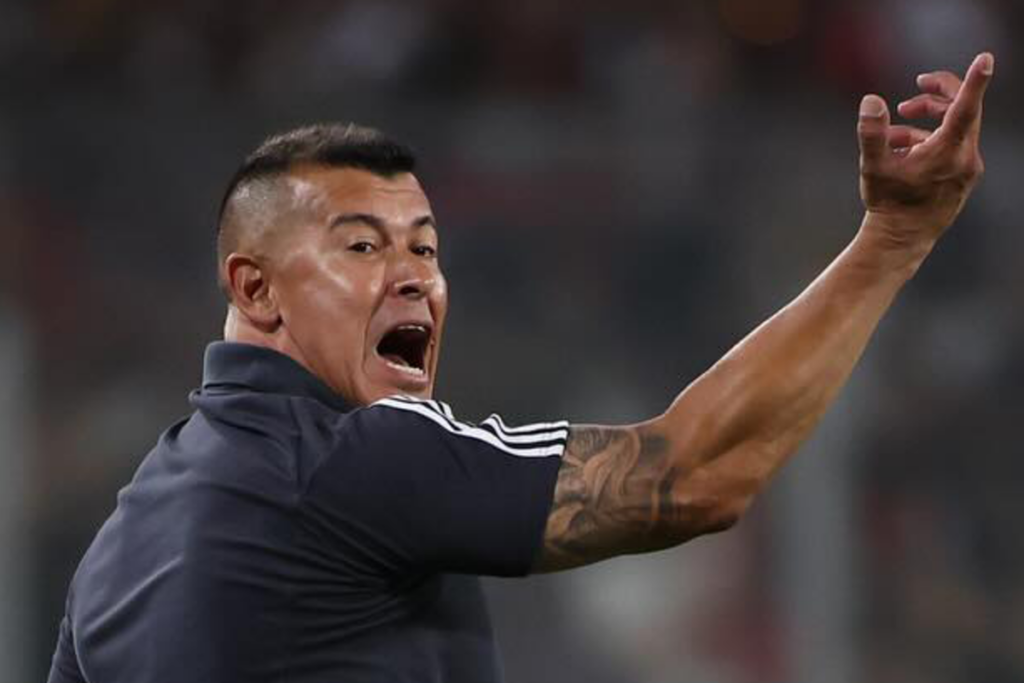 Jorge Almirón levanta su brazo y reclama eufórico una situación en pleno partido como director técnico de Colo-Colo.
