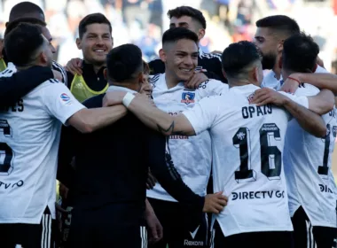 Futbolistas de Colo-Colo se abrazan y sonríen durante un partido en la temporada 2020.