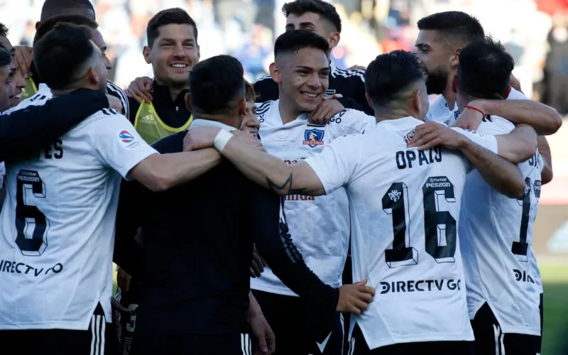 Futbolistas de Colo-Colo se abrazan y sonríen durante un partido en la temporada 2020.