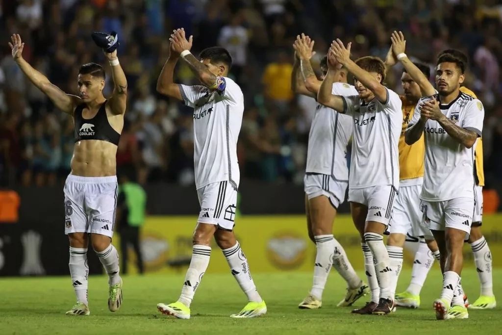 Jugadores de Colo-Colo aplaudiendo con los brazos en alto.