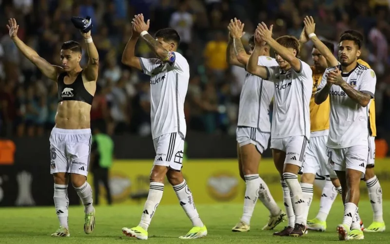 Jugadores de Colo-Colo aplaudiendo con los brazos en alto.