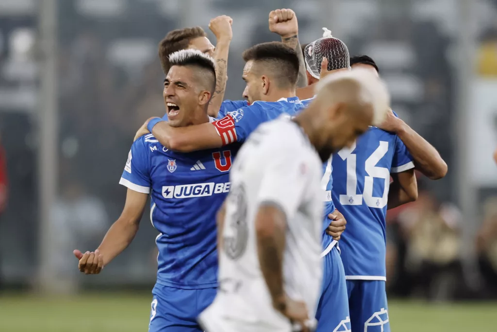 Jugadores de Universidad de Chile celebrando ante un cabizbajo Arturo Vidal.