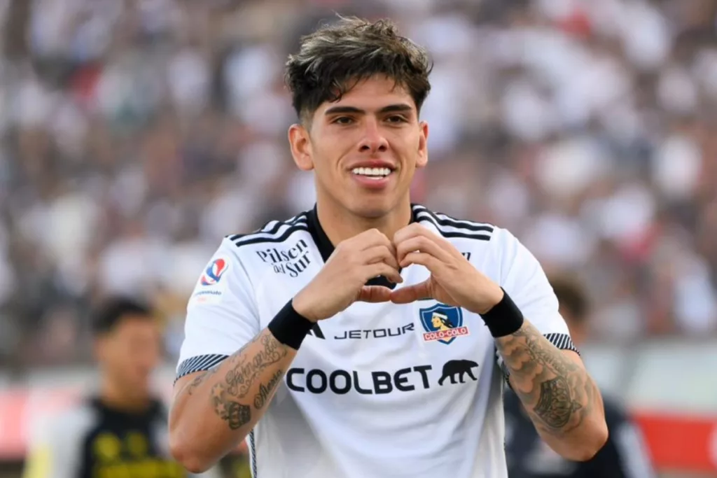 Carlos Palacios realiza un gesto de un corazón con sus manos en plena celebración de un gol con la camiseta de Colo-Colo durante la temporada 2024.