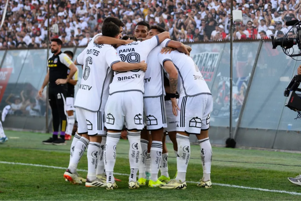 Futbolistas de Colo-Colo abrazados en el campo de juego