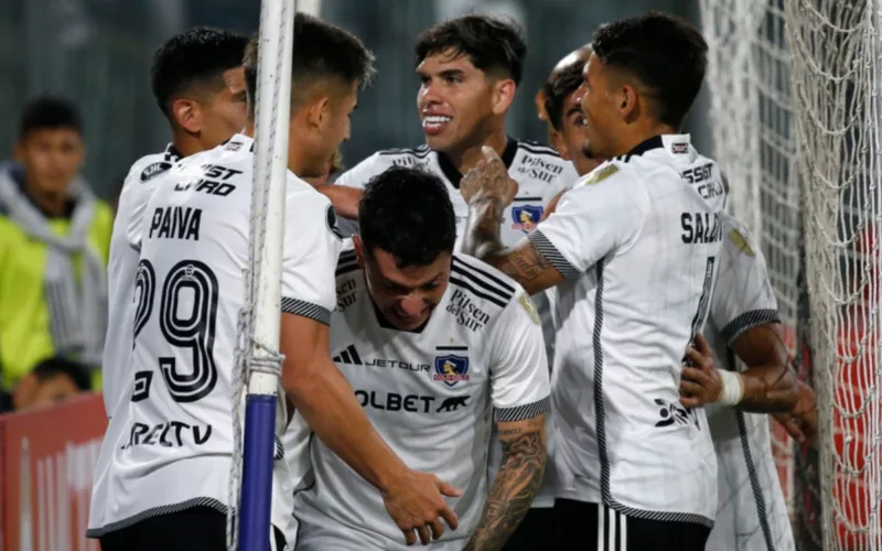 Futbolistas de Colo-Colo sonríen y se abrazan para celebrar un gol en la Copa Libertadores 2024