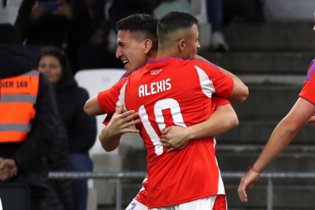 Primer plano de Alexis Sánchez con la camiseta de la Selección Chilena en sus manos.