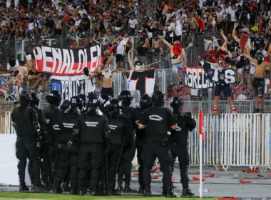 Policía uniformada de Chile mira a los hinchas de Colo-Colo apostados en el sector norte del Estadio Nacional en plenos incidentes en la Supercopa 2024.