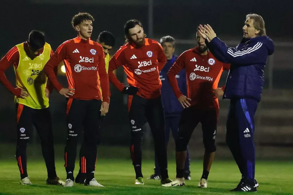 Ricardo Gareca imparte una instrucción y sus jugadores de la Selección Chilena mira atentos.
