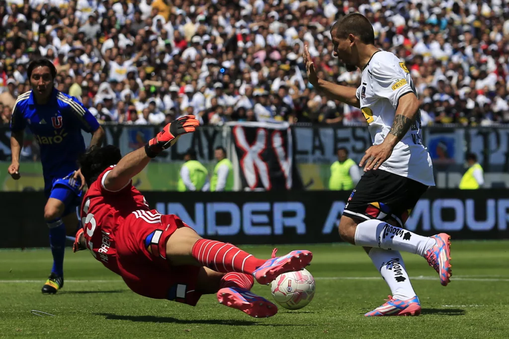 Emiliano Vecchio encarando al portero de Universidad de Chile, Johnny Herrera, en pleno Superclásico con la camiseta de Colo-Colo en el Estadio Monumental.