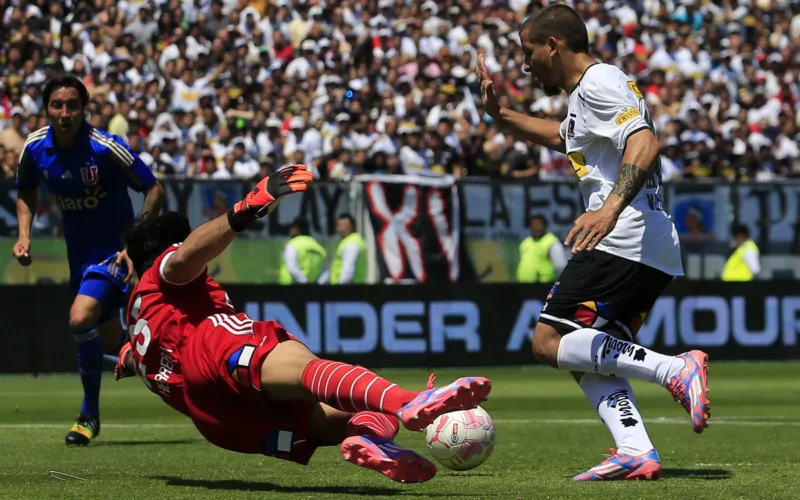 Emiliano Vecchio encarando al portero de Universidad de Chile, Johnny Herrera, en pleno Superclásico con la camiseta de Colo-Colo en el Estadio Monumental.