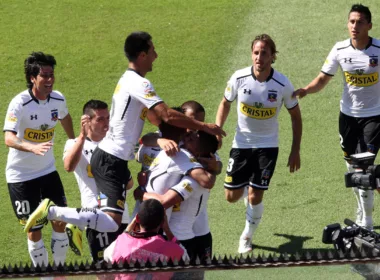 Futbolistas de Colo-Colo durante la temporada 2014 celebrando un gol y se abrazan con evidentes rostros de euforia y felicidad.